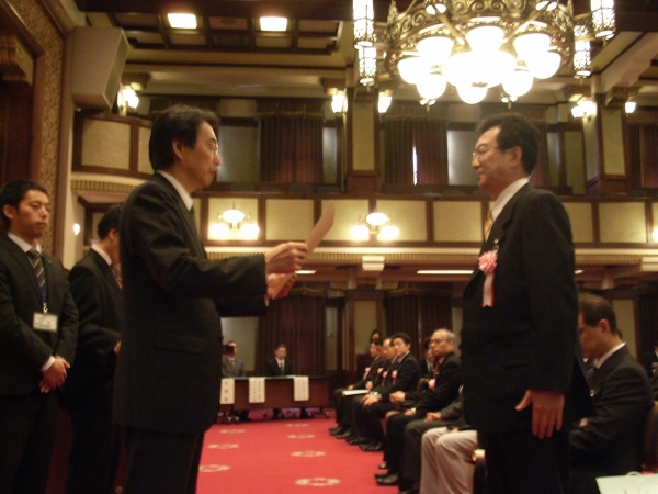 緊張した面持ちの尾作晃社長に黒川副知事から表彰状が手渡された