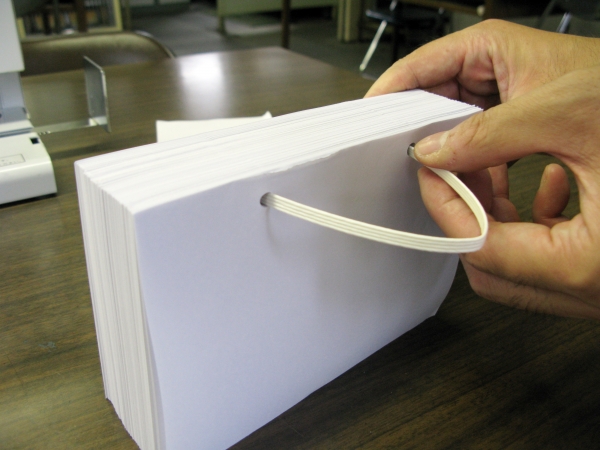 ②紙に差し込み、2つの折り目が中央にくるように貼る