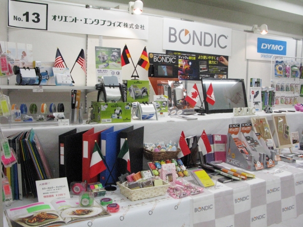 輸入商品の文具・雑賀を扱うオリエント・エンタプライズは、商品がどこの国の商品かをひと目で分けるように展示