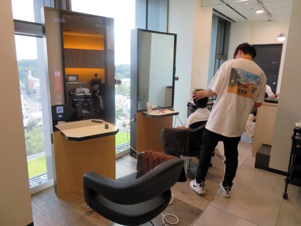 ヘアーサロン、ミラーはサイネージで雑誌が映し出され読める