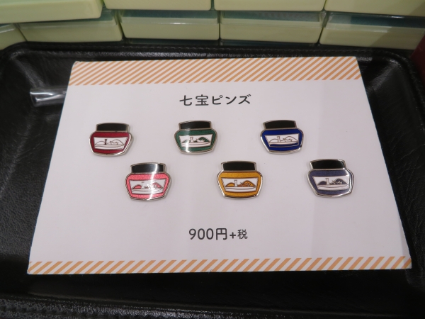 ナガサワ文具センター、オリジナル「Kobe INK 七宝焼きのピンバッチ」。「青い波止場ブルー」「赤い北の異人館レッド」「グリーンの六甲グリーン」etc
