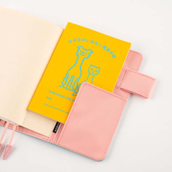 「ほぼ日のいぬねこ健康手帳」 946円（税込） オリジナル手帳カバーのポケットに収まるサイズです。