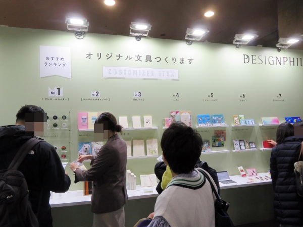 【オリジナル文具つくります】デザインフィルブースでは、定番人気のオリジナルクリップに加え、『ペーパーホチキスノート』『ダンボールカッター』『ペーパーパッド』などの人気アイテムを、おすすめランキング形式で紹介。カスタマイズの事例もあわせて展示