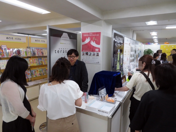 文具王 高畑正幸氏からアイデア文具 新商品の説明を受ける来会者