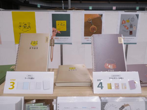 簡単にとじ具が開け閉めできるので、自分でオリジナルノートが作れちゃいます「カスタマイズ オープンリングノート」。今回のコラボレーション先は大阪繋がりの「COBATO STANDドラキチ」さん。焼印が可愛いドラキチさんのイラストが入った表紙や、美味しいどら焼きがイメージできるコラボ　LIHIT LAB.