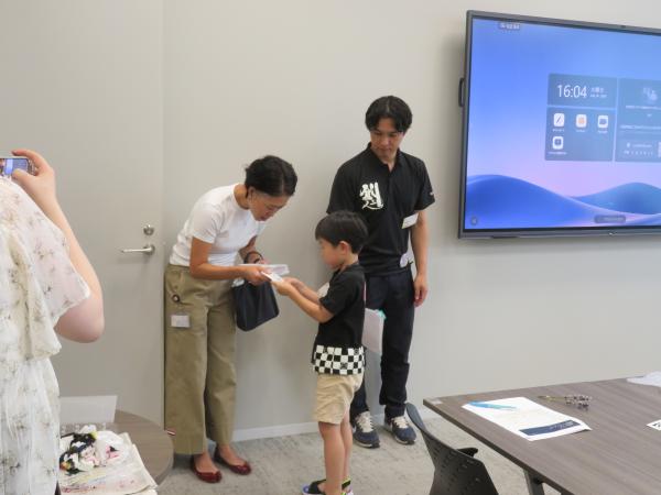 今日一日、オカモトヤの商品開発として働いた分のお給料をもらう子どもたち